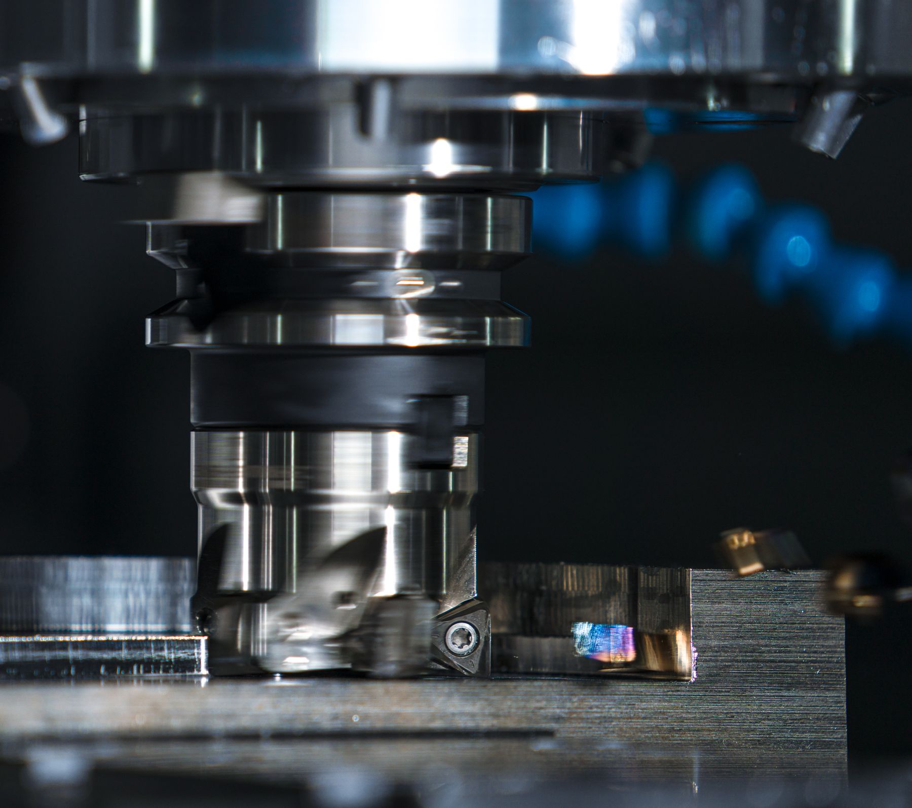 Milling tool machining a metal workpiece, with chips forming at the cutting edge